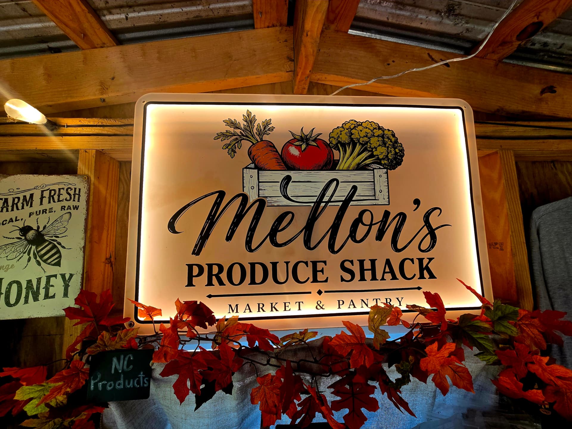 The lit Melton's Produce Shack Market & Pantry sign