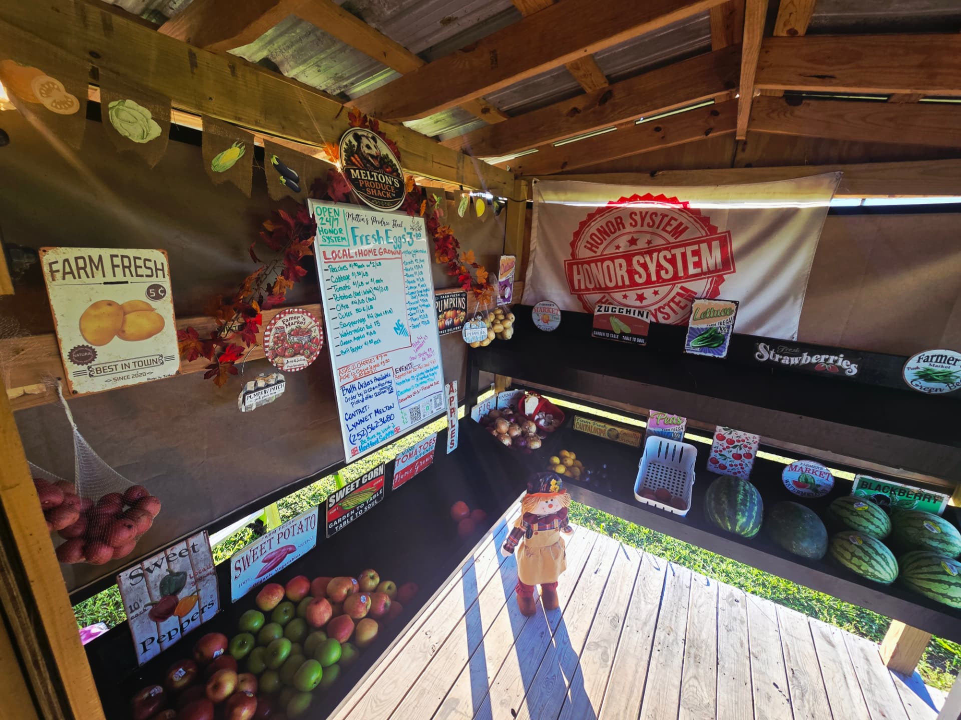 Produce tables and the honor-system price board inside the shack